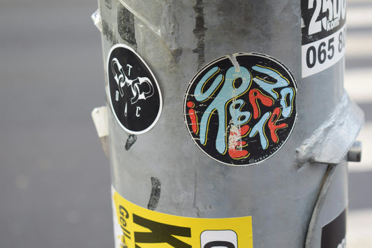 Decal vs sticker example on a street pole showing colorful designs