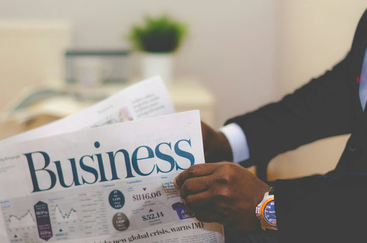 Man reading a business newspaper, representing ideas on how to come up with a business name and create a strong brand identity.